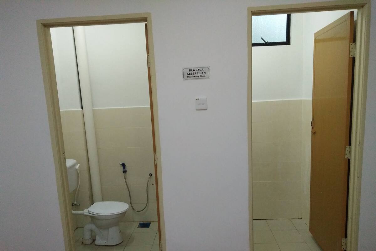 Un baño pequeño y estrecho con inodoro y ducha.