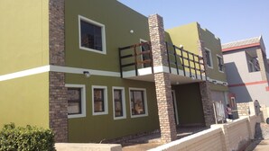 A two-story building with a green facade, multiple windows, and a balcony. - Jessma Bed and Breakfast (Walvis Bay)