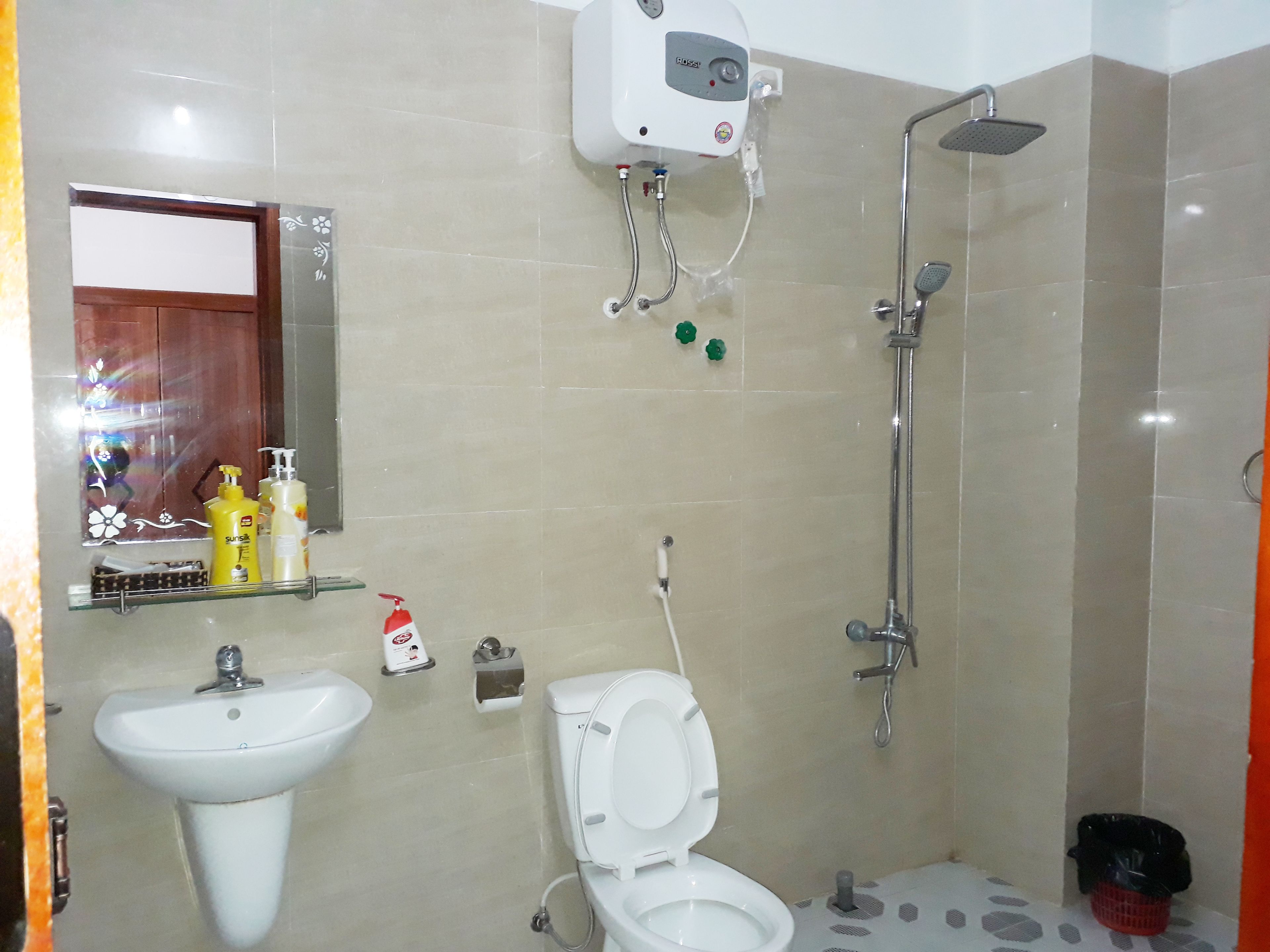 Un baño con lavamanos, inodoro y ducha.