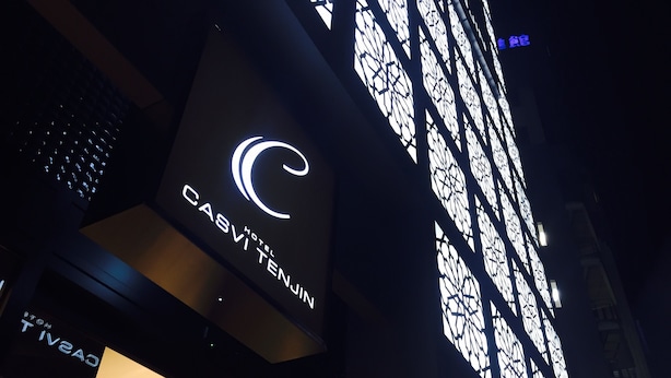 Een hotelgevel met een opvallend logo en borden.