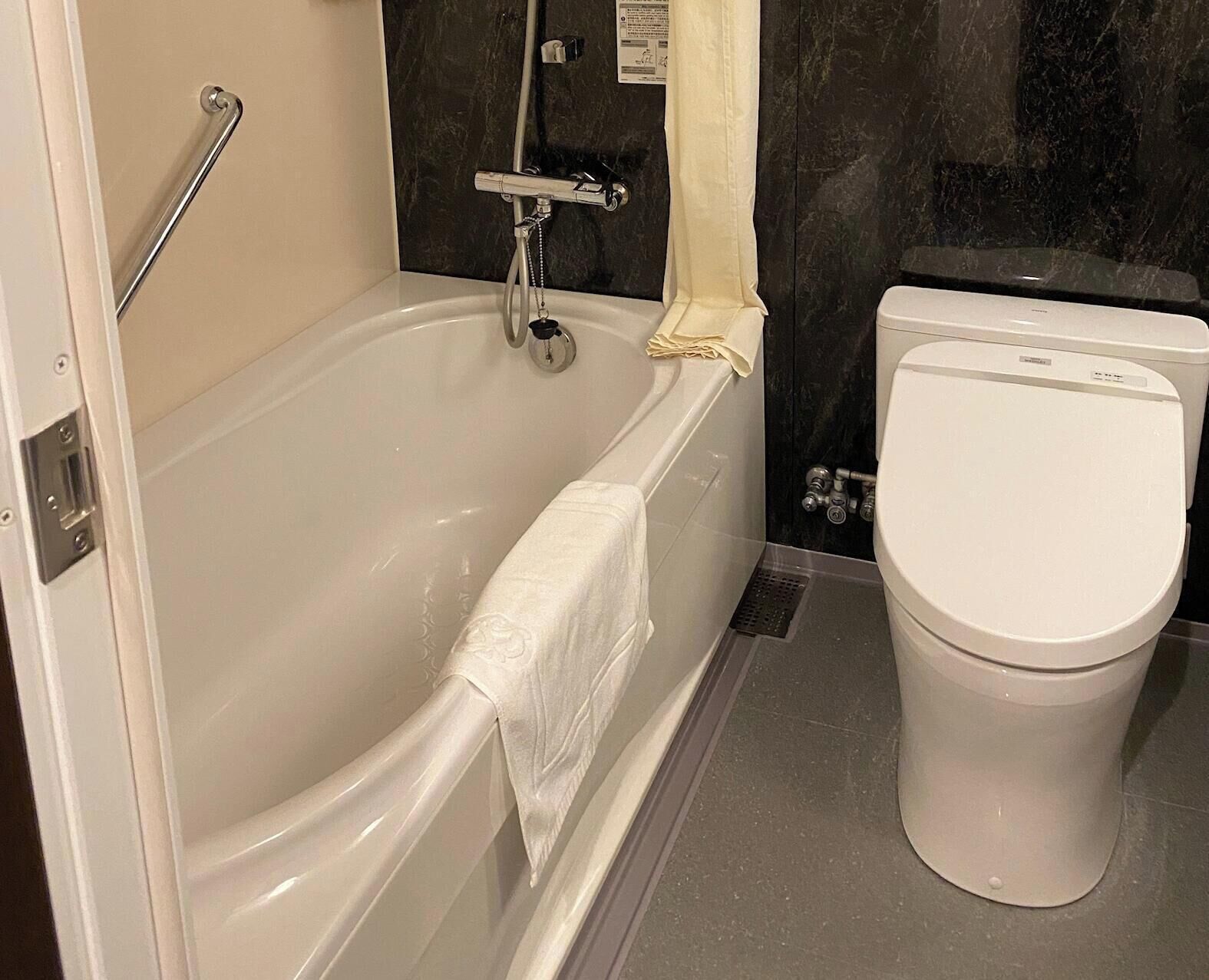 Ein Badezimmer mit Badewanne, Toilette und Dusche.