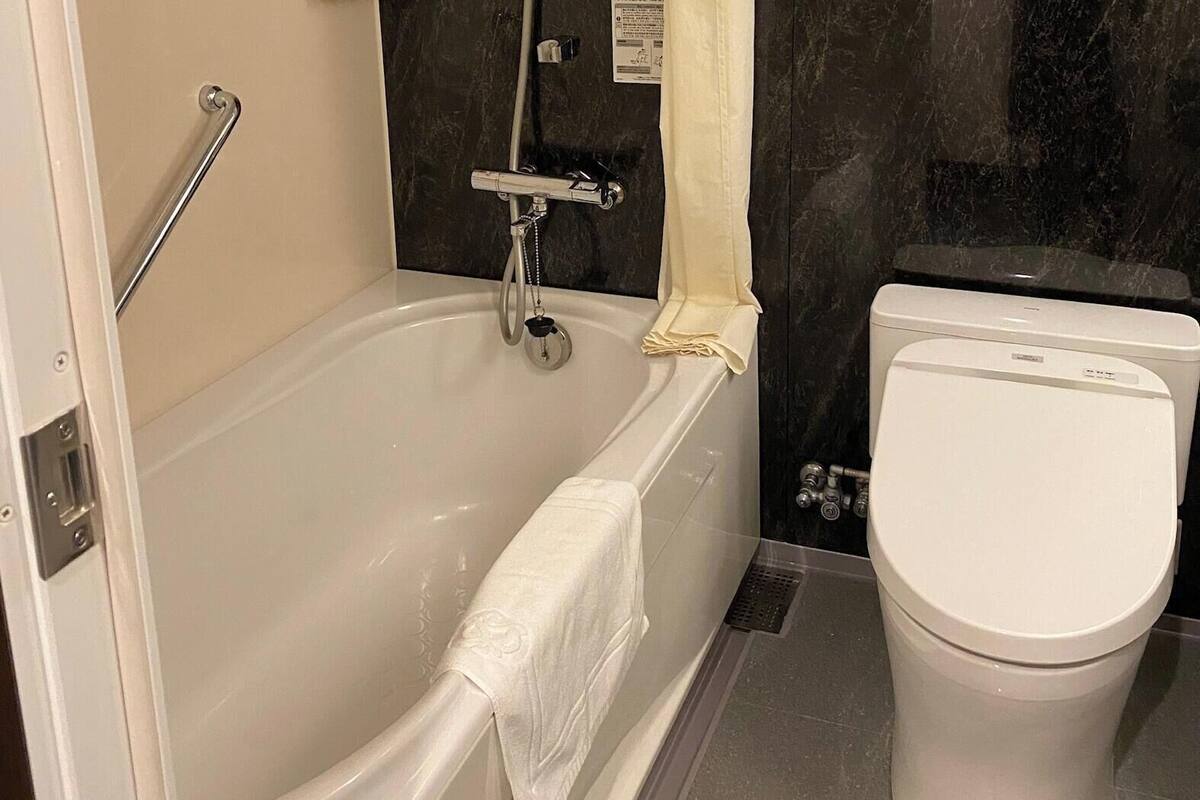 Un baño con bañera, inodoro y ducha.