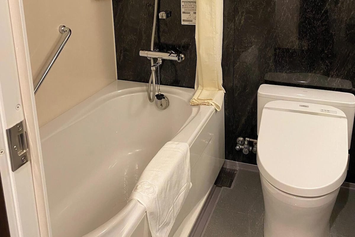 Un baño con bañera, inodoro y ducha.