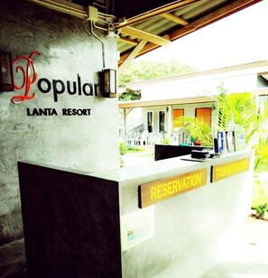 A reception desk at Lanta Resort with a sign for Popular and Reservation. - Popular Lanta Resort (Ko Lanta)