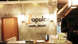 Bancada de recepção no Lanta Resort, com sinalização 'Popular', um balcão de reservas e um balcão de informações turísticas.