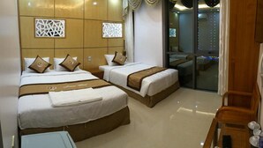 Une chambre d’hôtel avec deux lits, une petite table et une chaise.