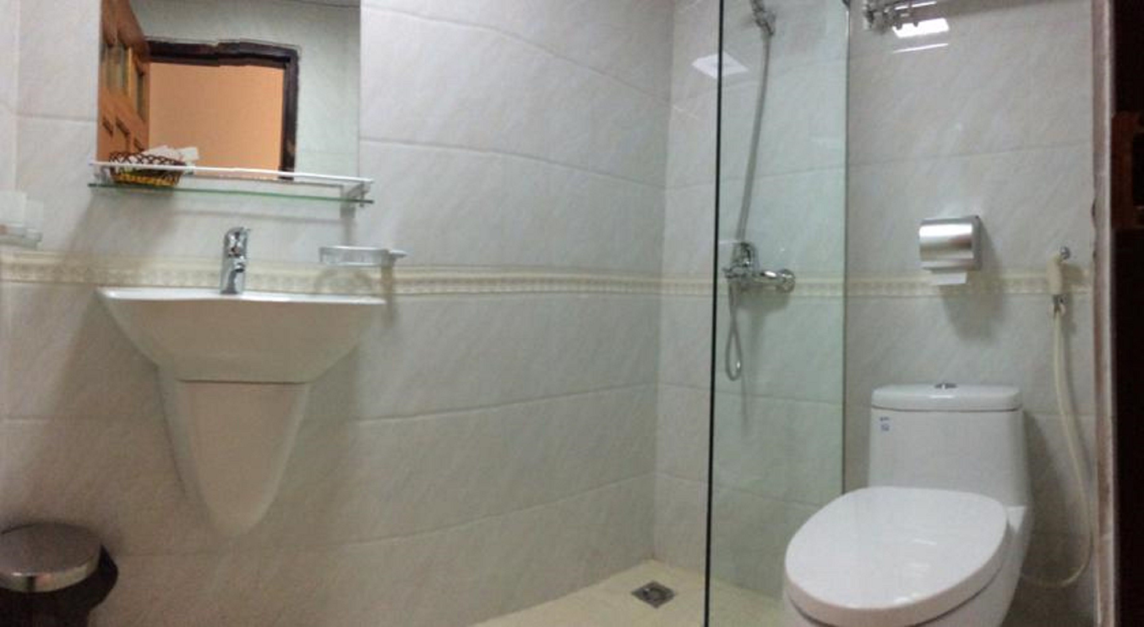 A bathroom with a sink, toilet, and glass-enclosed shower.