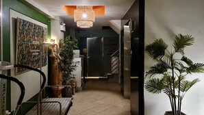 A hallway with a bed, a staircase, and a refrigerator. - Sathorn Terrace Apartment (Bangkok)