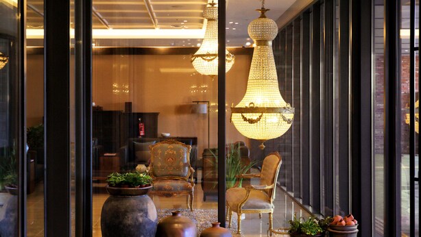 A lobby with large vases, a chandelier, and classic furniture. - Odri Inn Jeju (Jeju City)