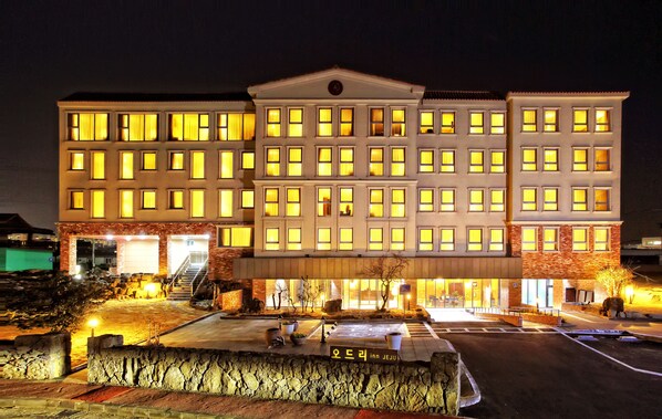 A multi-story hotel with a symmetrical facade, large windows, and a central entrance with a staircase.