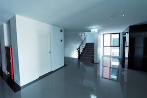 A modern hallway with a staircase, a door, and a window.