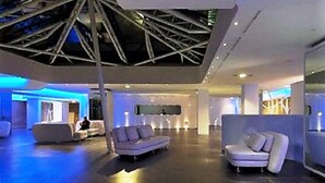 A modern lobby with a high ceiling, recessed lighting, and contemporary furniture. - A Point Arezzo Park Hotel (Arezzo)