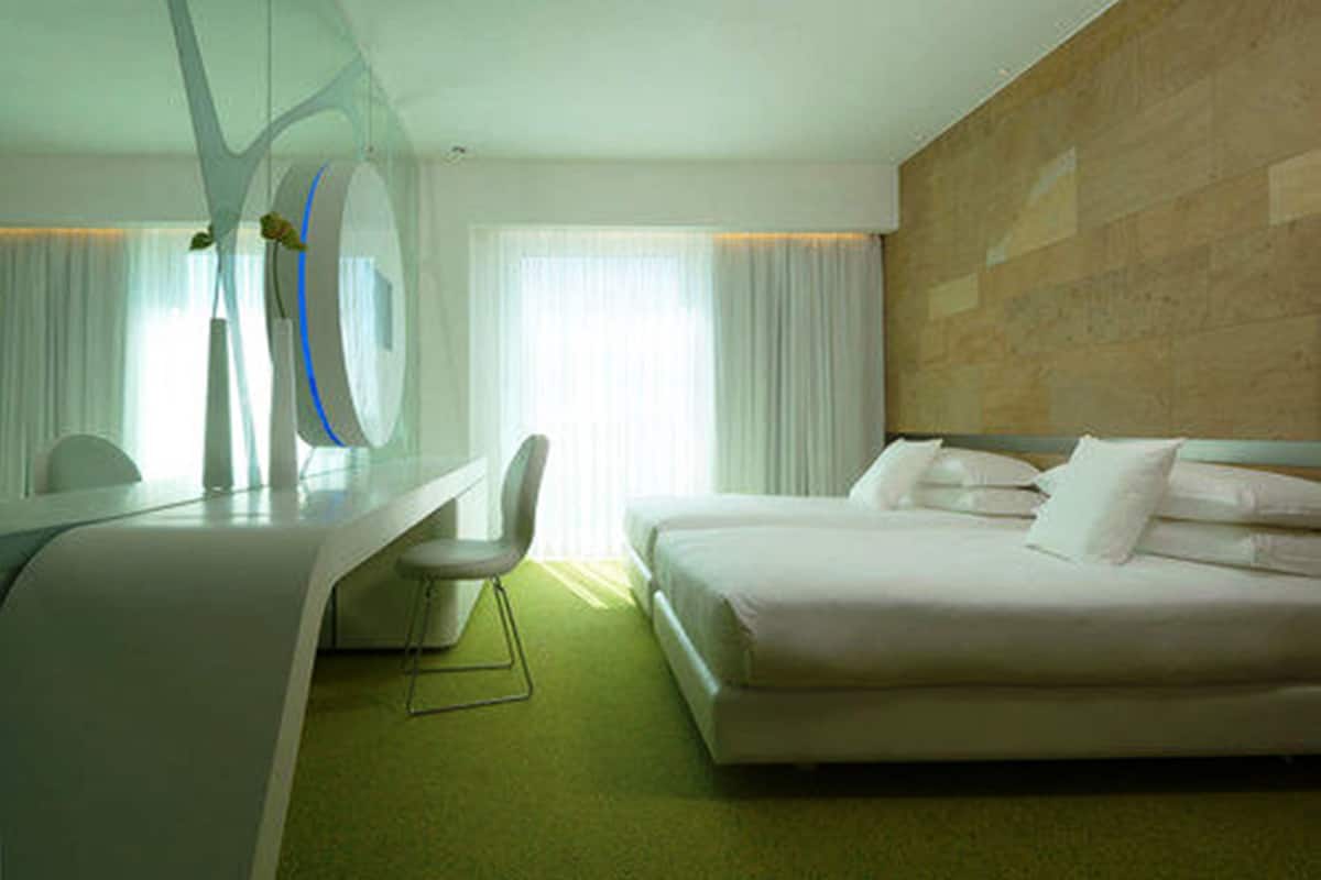 Une chambre d’hôtel moderne, équipée d’un lit, d’un bureau et d’une chaise.