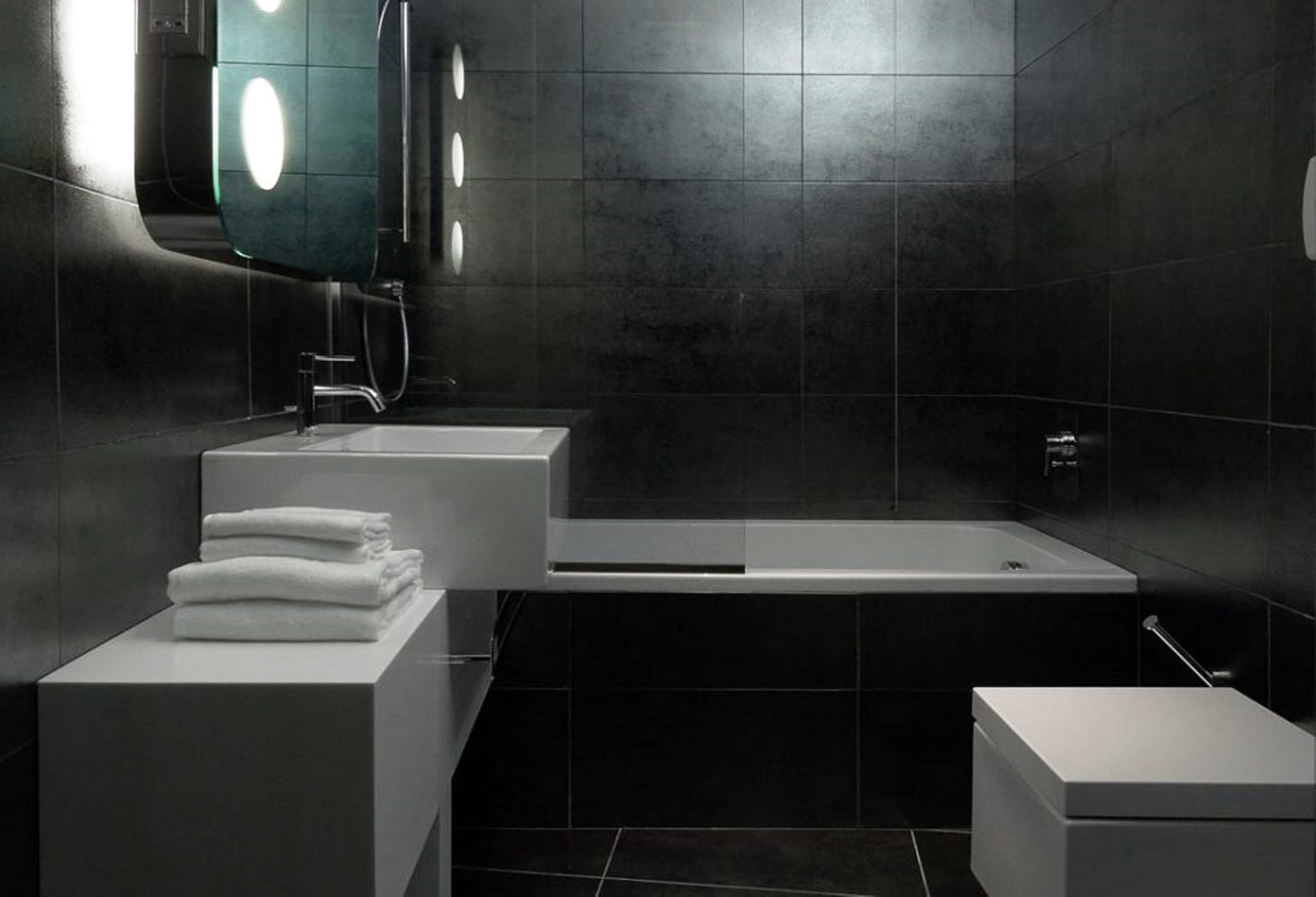 Une salle de bain moderne dotée d’une grande baignoire, d’un lavabo séparé et de toilettes.