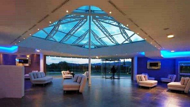 A spacious lobby with a large glass ceiling, comfortable seating, and a view of the outdoors. - A Point Arezzo Park Hotel (Arezzo)