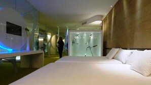 A modern hotel room with a large bed, a bedside table, and a glass shower enclosure. - A Point Arezzo Park Hotel (Arezzo)