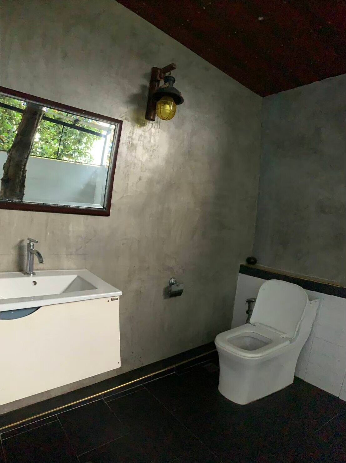 A bathroom with a white sink, a toilet, and a mirror.