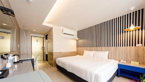 A modern hotel room with a large bed, a desk, and a mirror. - Princess & Elephant Hotel (Tainan)
