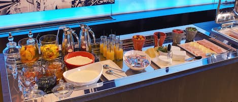 A buffet with various food items and beverages.