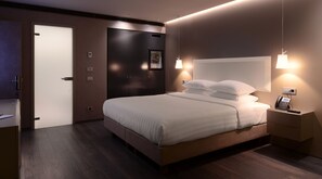 Une chambre d’hôtel moderne avec un grand lit, des tables de chevet, un téléphone et une porte.