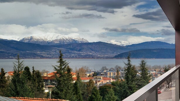 Un balcon avec vue sur un lac et des montagnes.
