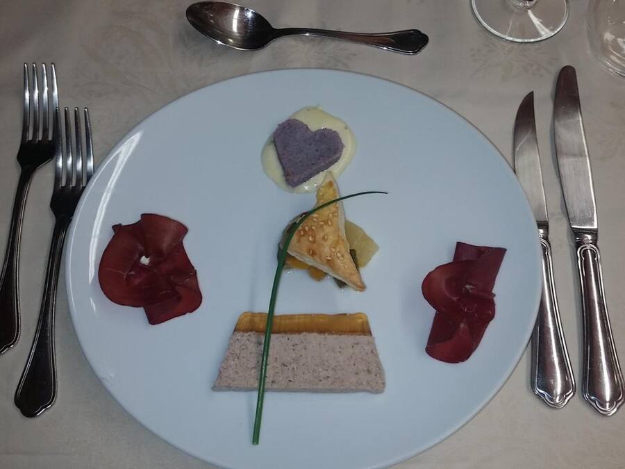 En tallrik med mat och bestick på ett bord.