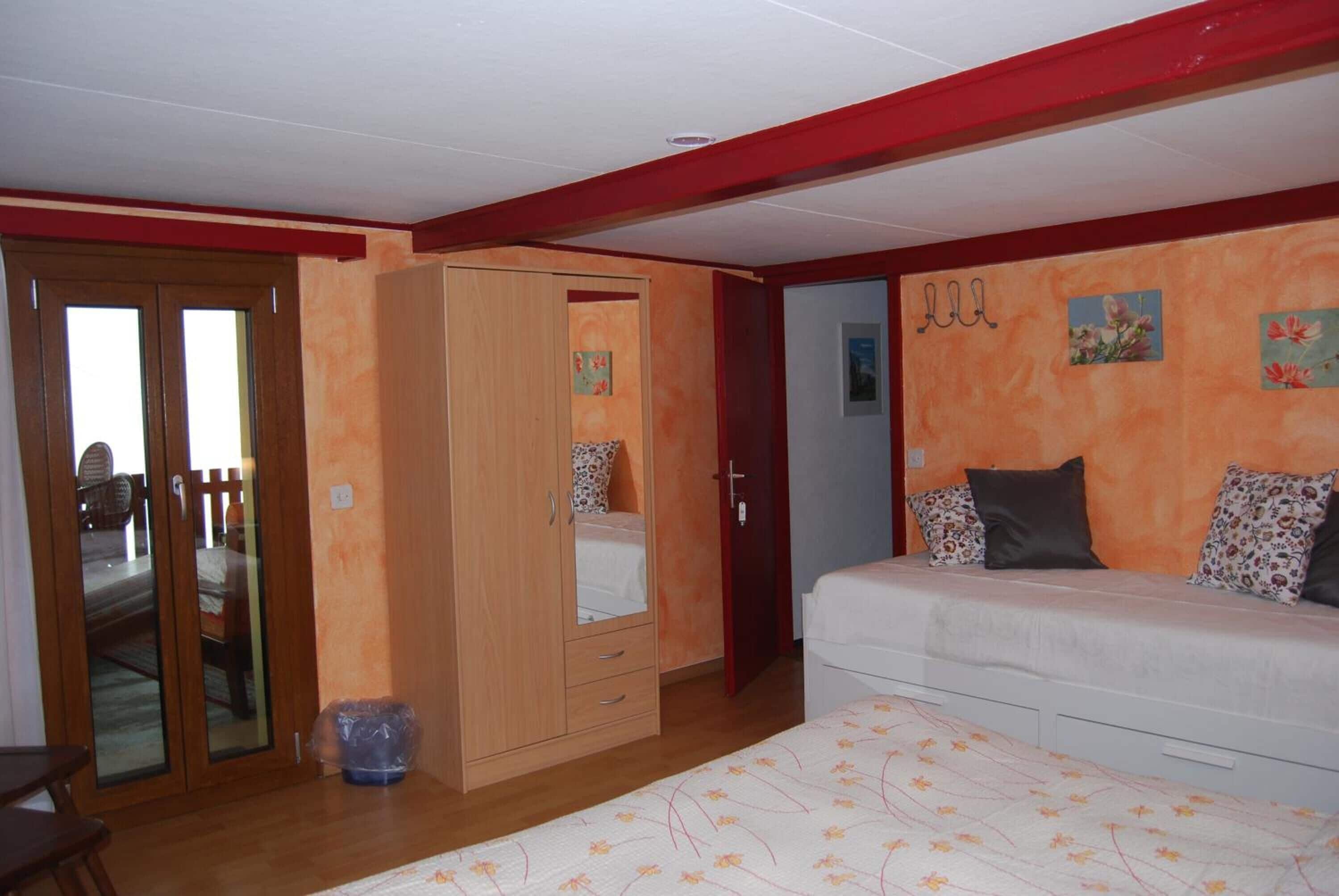 Un dormitorio con cama, armario y puerta que da a otra habitación.