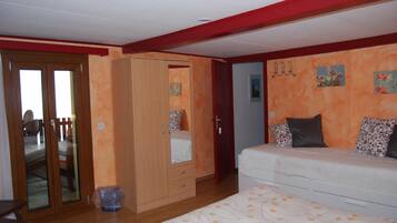 Un dormitorio con cama, armario y puerta que da a otra habitación.