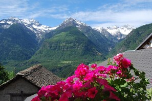 A mountain landscape with snow-capped peaks and lush green valleys. - Osteria Anzonico (Faido)