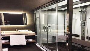A modern bathroom with a glass-enclosed shower, a vanity with a mirror, and a towel rack. - Private Luxury Suite (Rome)