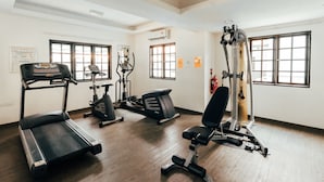 A gym with treadmills, elliptical machines, and a weight bench. - Kertih Damansara Inn (Kerteh)