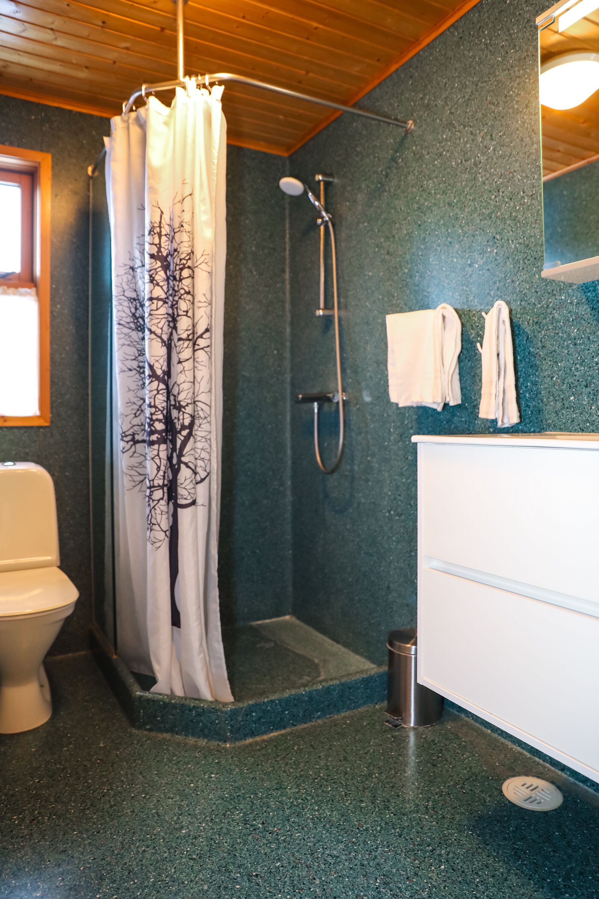 A bathroom with a shower, a toilet, and a sink.