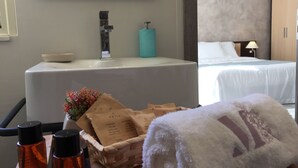A hotel bathroom with a bathtub, a sink, and toiletries. - B&B Marricriu (Avola)