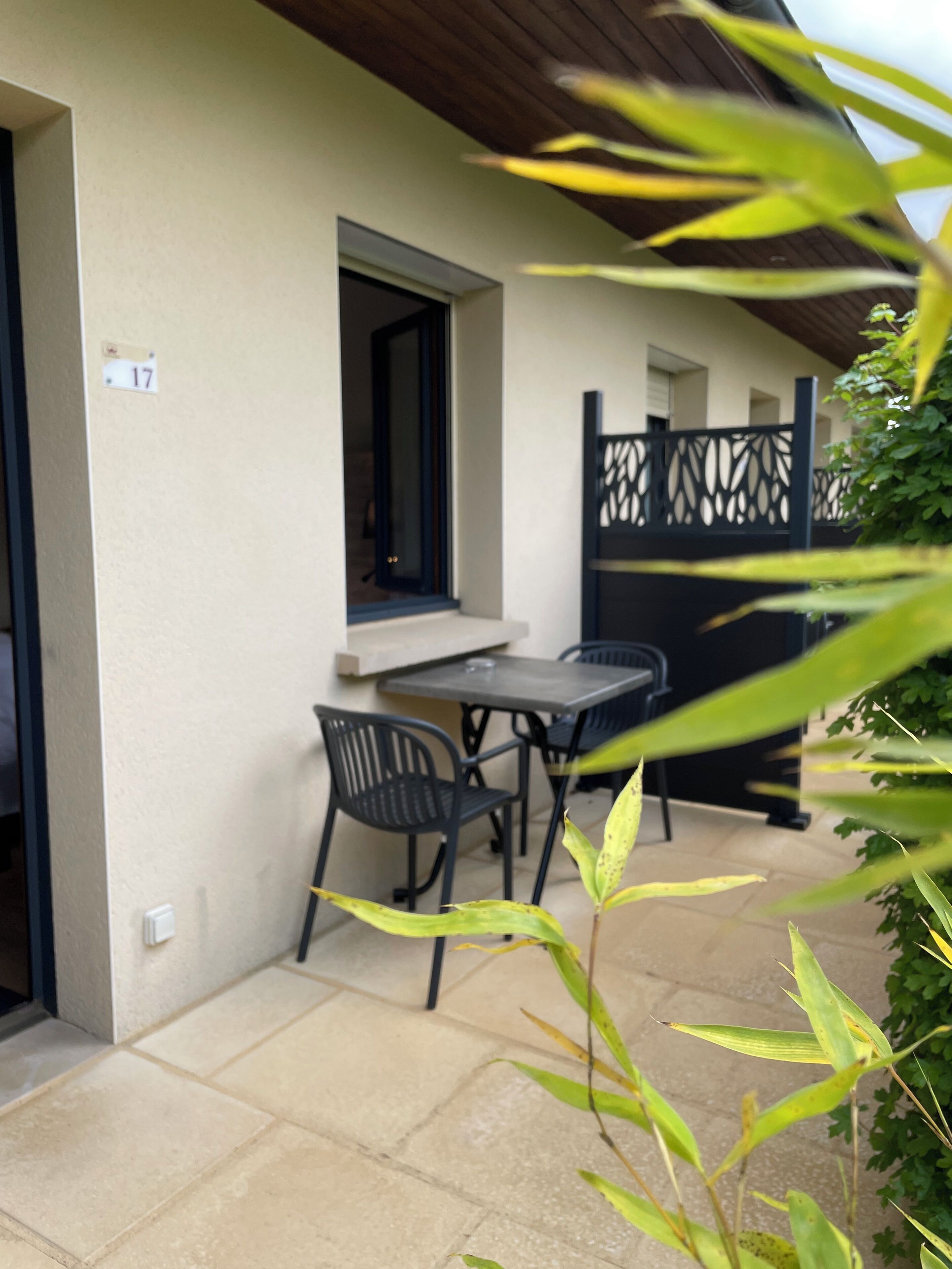 A patio with a table and chairs, a window, and a door.