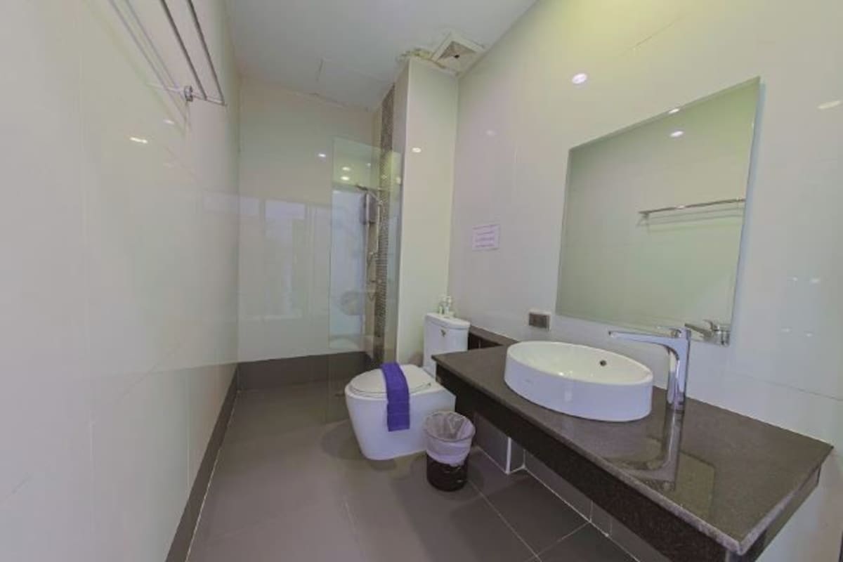 A modern bathroom with a glass shower enclosure, a white toilet, and a sink with a mirror.