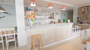 A modern kitchen with white cabinetry, a marble countertop, and pendant lighting. - 168 Studio Hotel Ubon Ratchathani (Ubon Ratchathani)