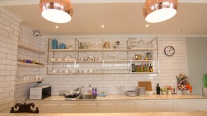 A kitchen with white tiled walls, a marble countertop, and two pendant lights. - 168 Studio Hotel Ubon Ratchathani (Ubon Ratchathani)
