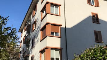 A multi-story building with a beige facade and brown window frames.