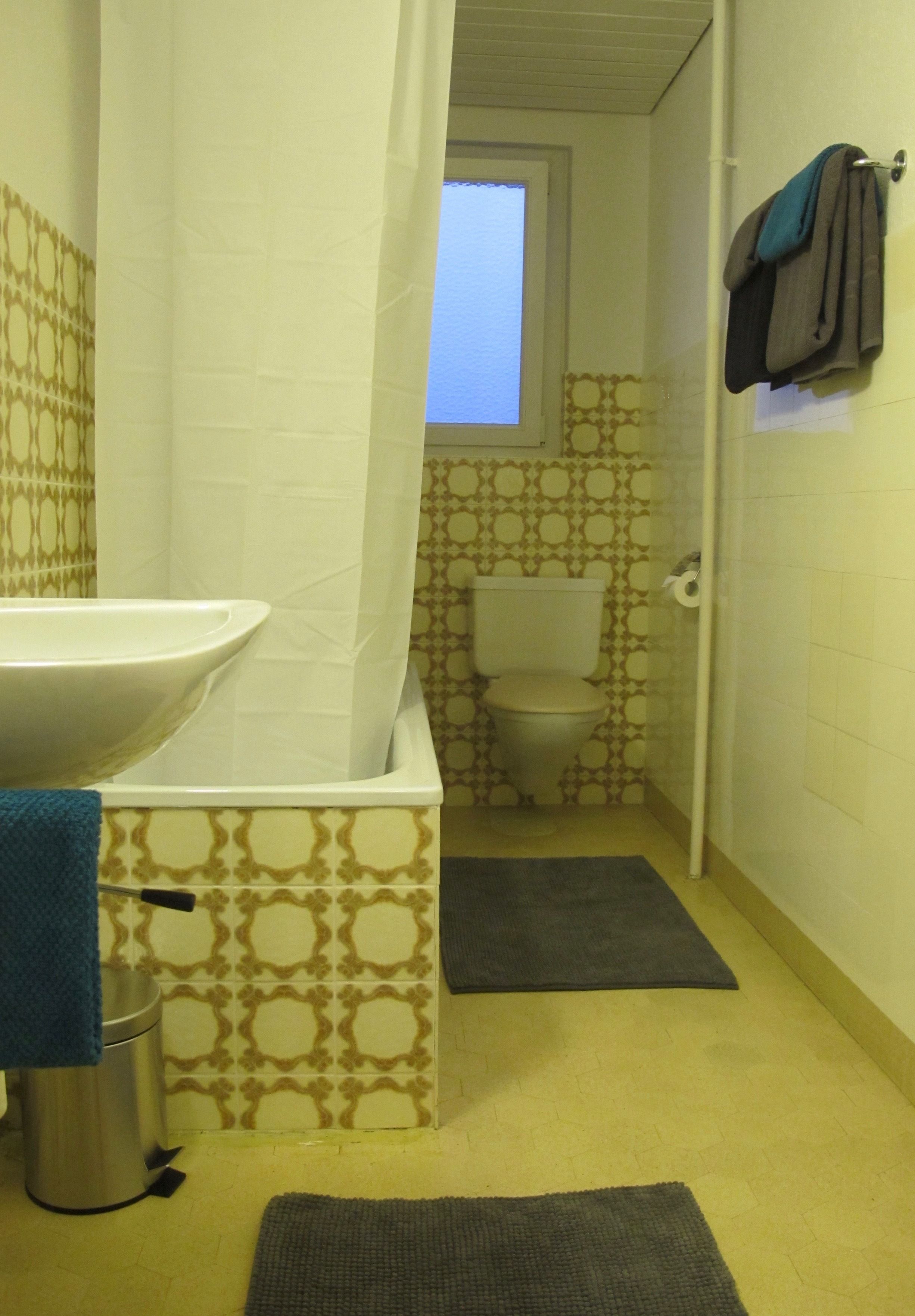 A bathroom with a sink, toilet, and shower curtain.