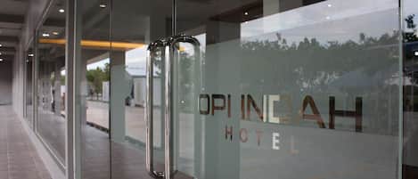 A hotel entrance with a glass door and a sign that reads "OPINIAH HOTEL".