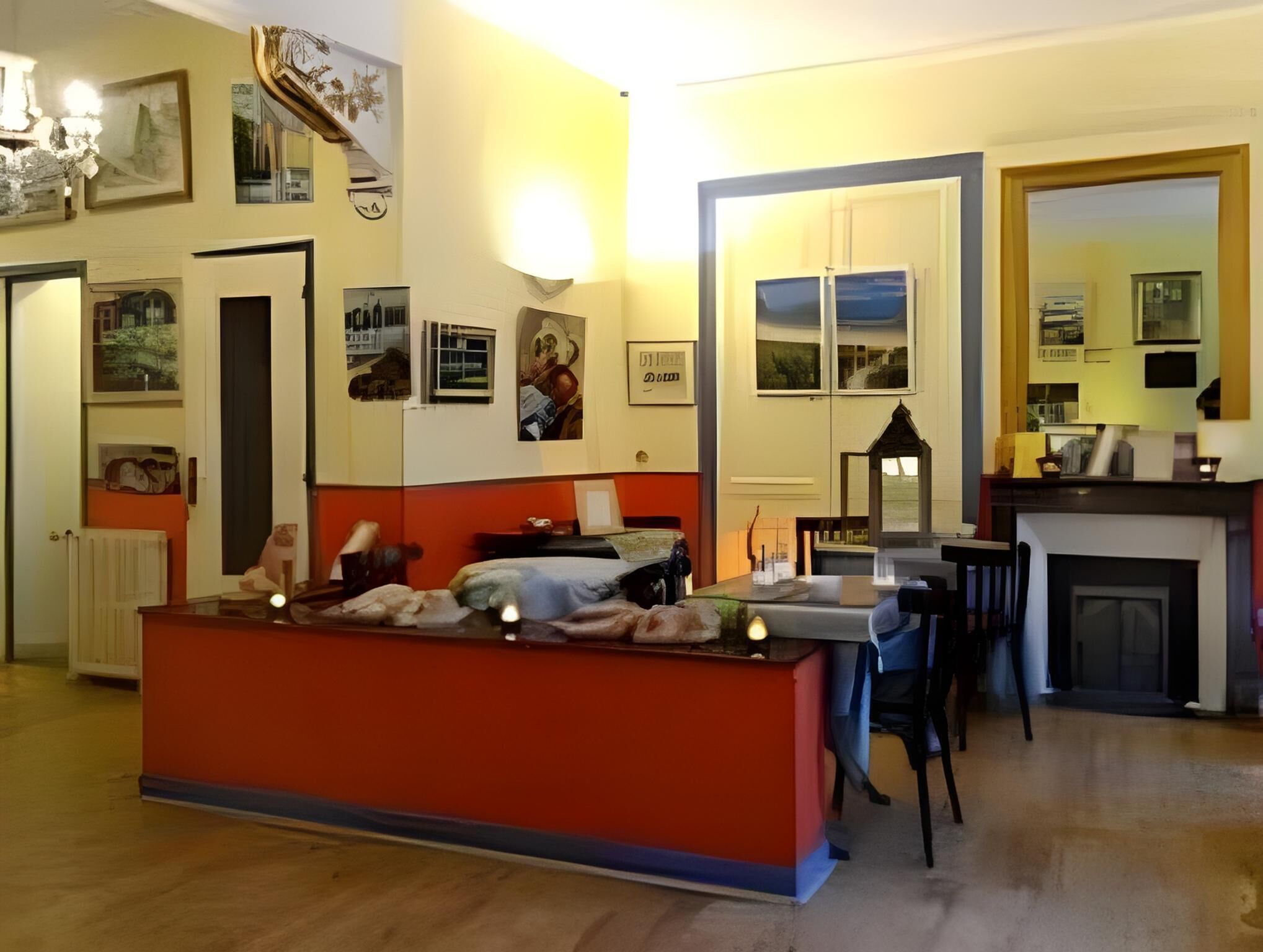 A room with a bed, a desk, a fireplace, and artwork on the walls.
