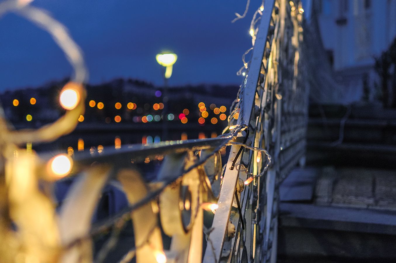 Een close-up van een metalen constructie met een vage achtergrond van lichtjes.
