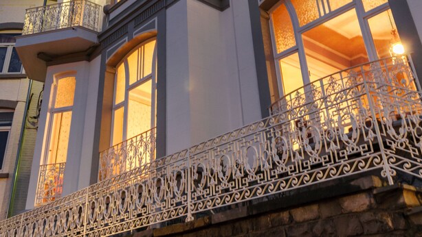 Un edificio histórico con balcones ornamentados y una torre del reloj.