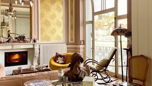 Una sala de estar con chimenea, un espejo grande y vistas al exterior a través de una ventana.