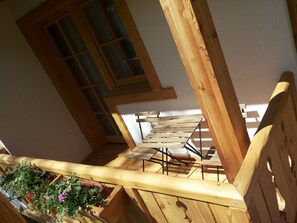 A wooden staircase with a view of a window and a plant. - Dalla Natura la Salute (Giustino)