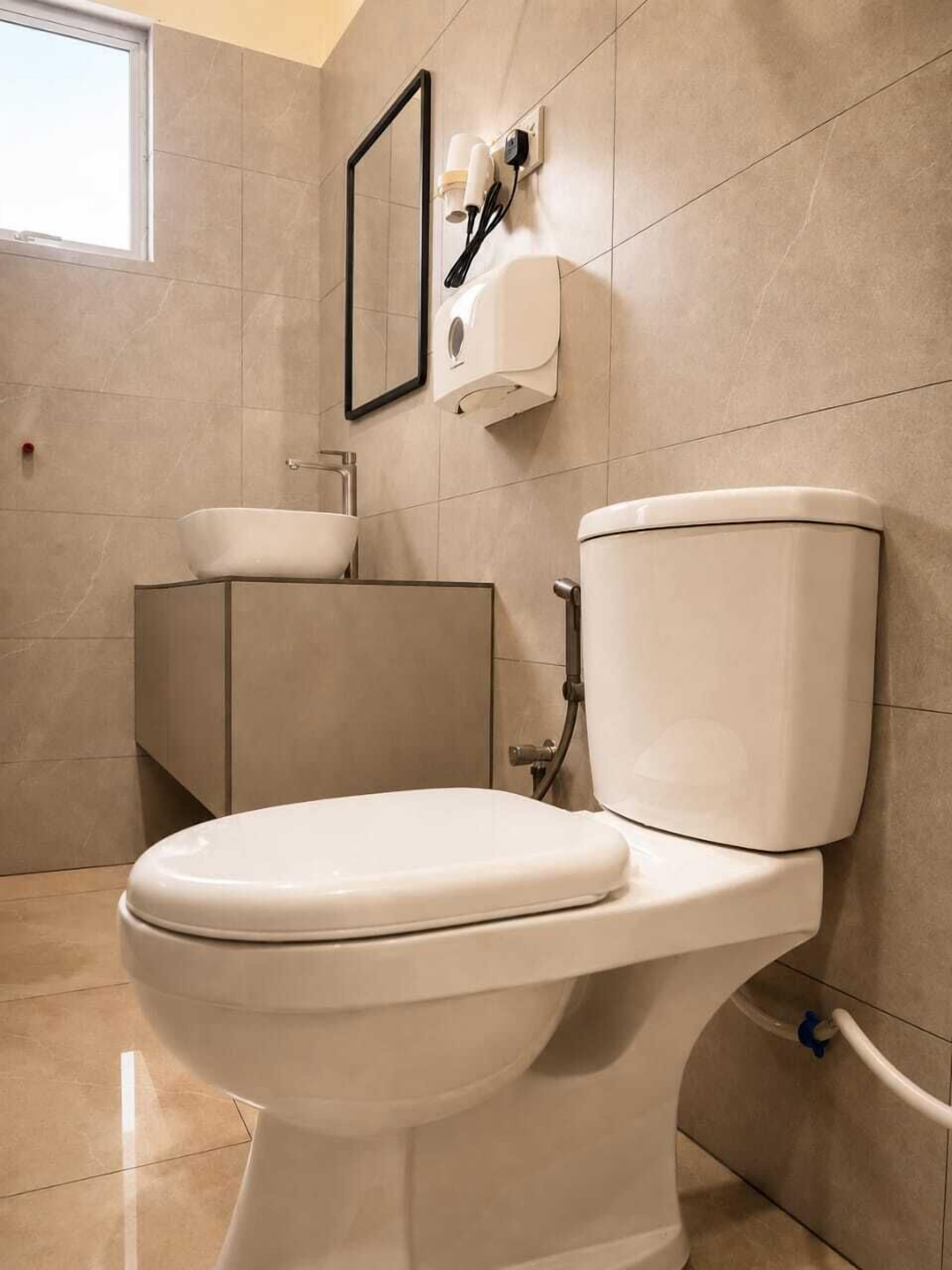 A modern bathroom with a toilet, sink, and mirror.