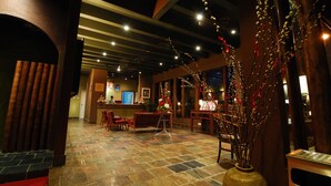 A lobby with a stone floor, wooden furniture, and a vase with branches. - RUMBIA RESORT VILLA Paka Terengganu  (Dungun)