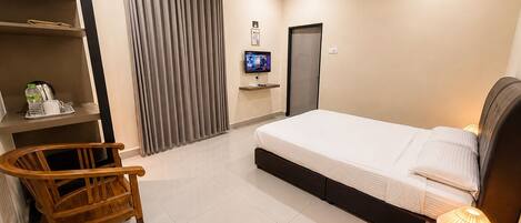 Habitación de hotel con cama, televisión, escritorio con silla, armario y aire acondicionado.