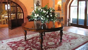 Ein Essbereich mit einem runden Tisch, einer floralen Dekoration und einer Pendelleuchte.