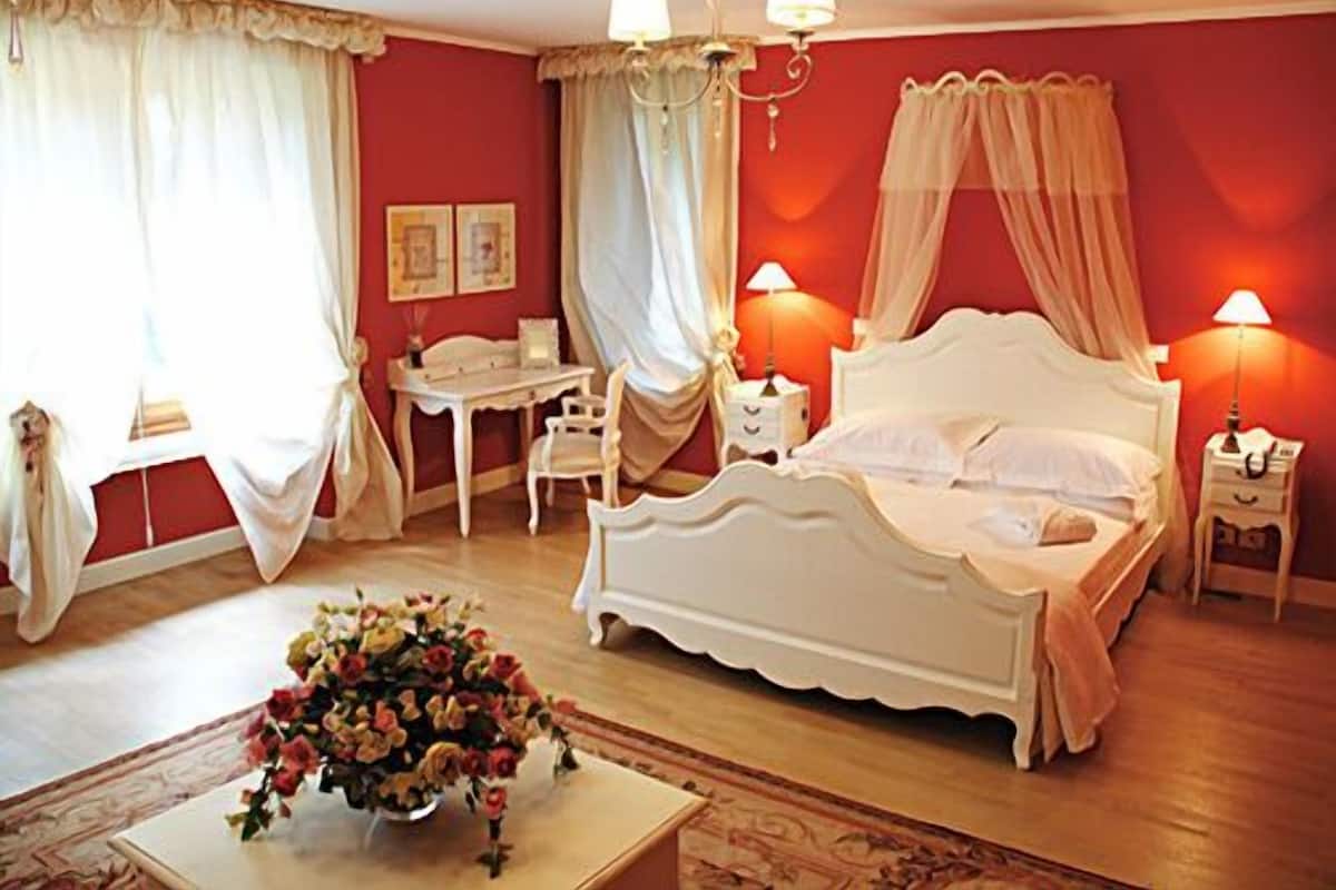 Un dormitorio con cama, escritorio, silla y mesita de noche.